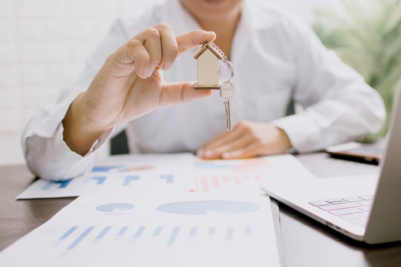 services-03 Real estate professional presenting a house model with keys, symbolizing property investment and ownership.