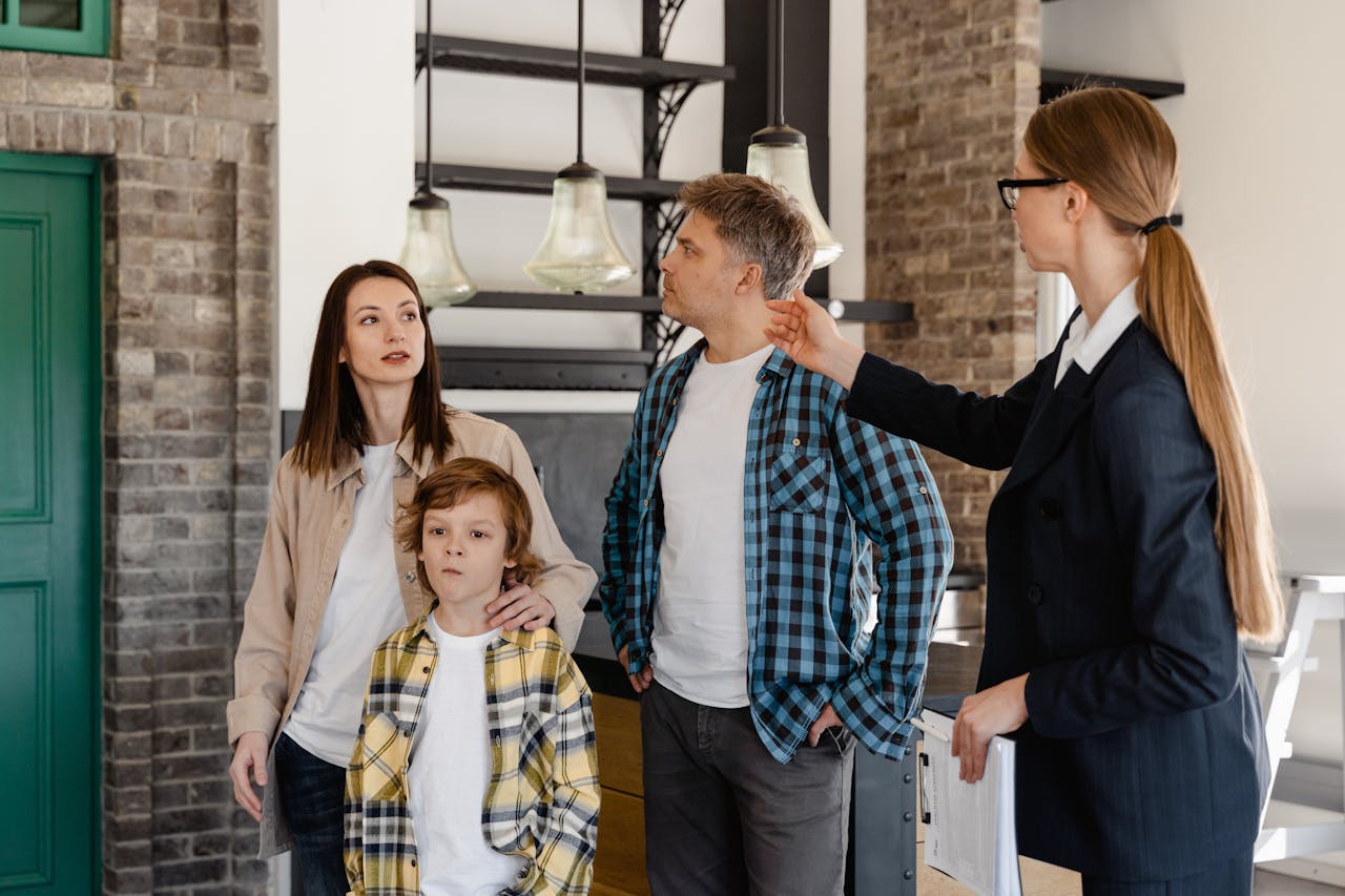 why-choose-us A family visits a modern home guided by a real estate agent during an open house tour.